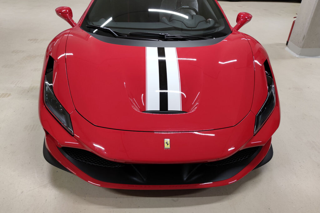 Roter Ferrari mit Akzentbeschriftung, Frontansicht – individuelles Fahrzeugdesign aus Stuttgart.